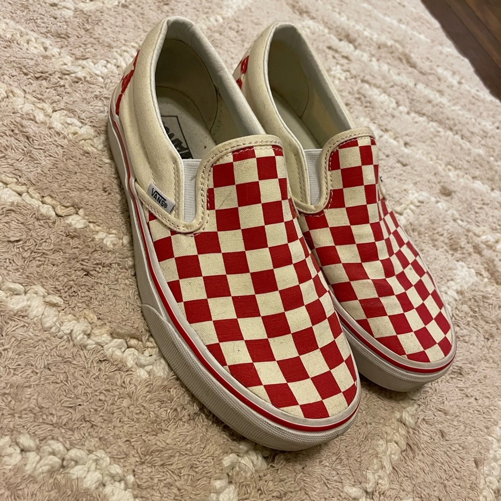 Red and off white checkerboard slip on vans